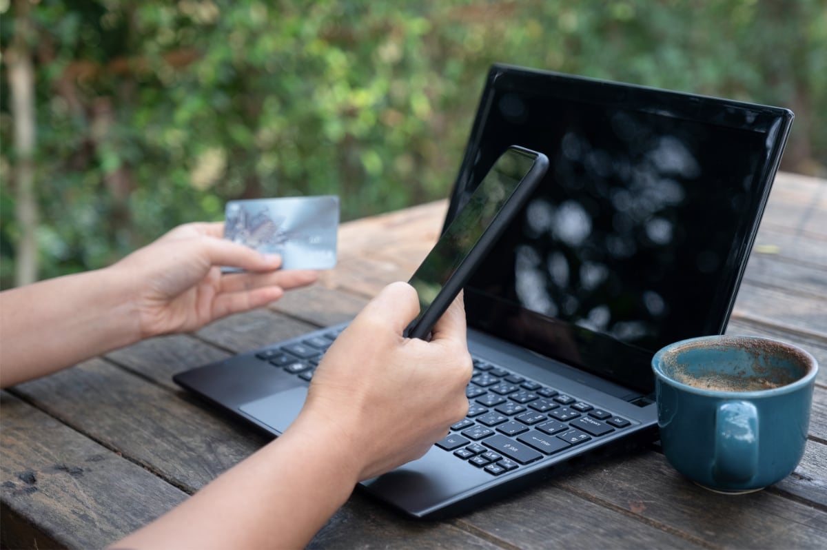 Person using a credit card and phone to pay for an online purchase
