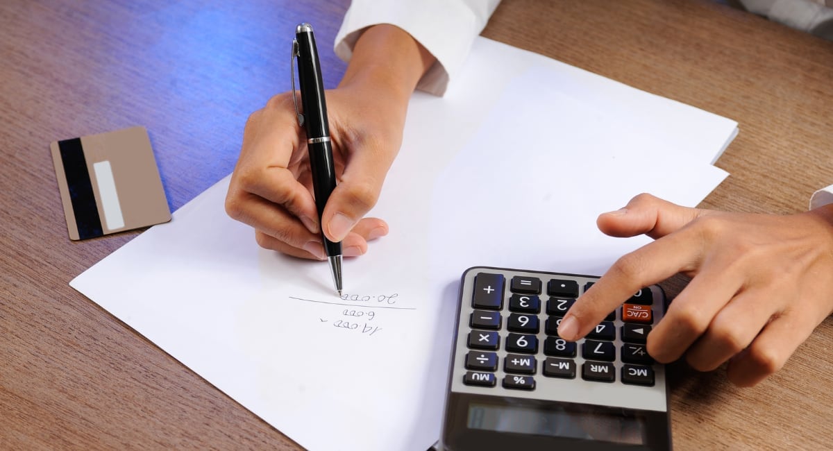 hands calculating acquirer fees for card acceptance