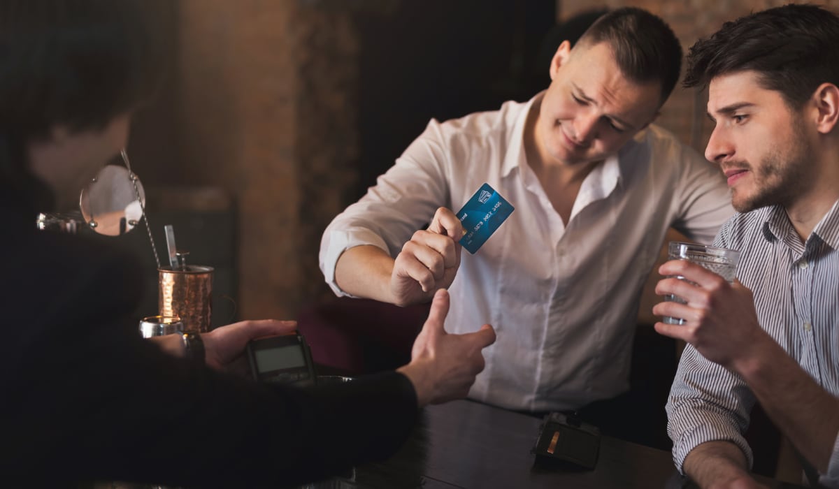 Men paying with card in a bar two men paying with card in a bar