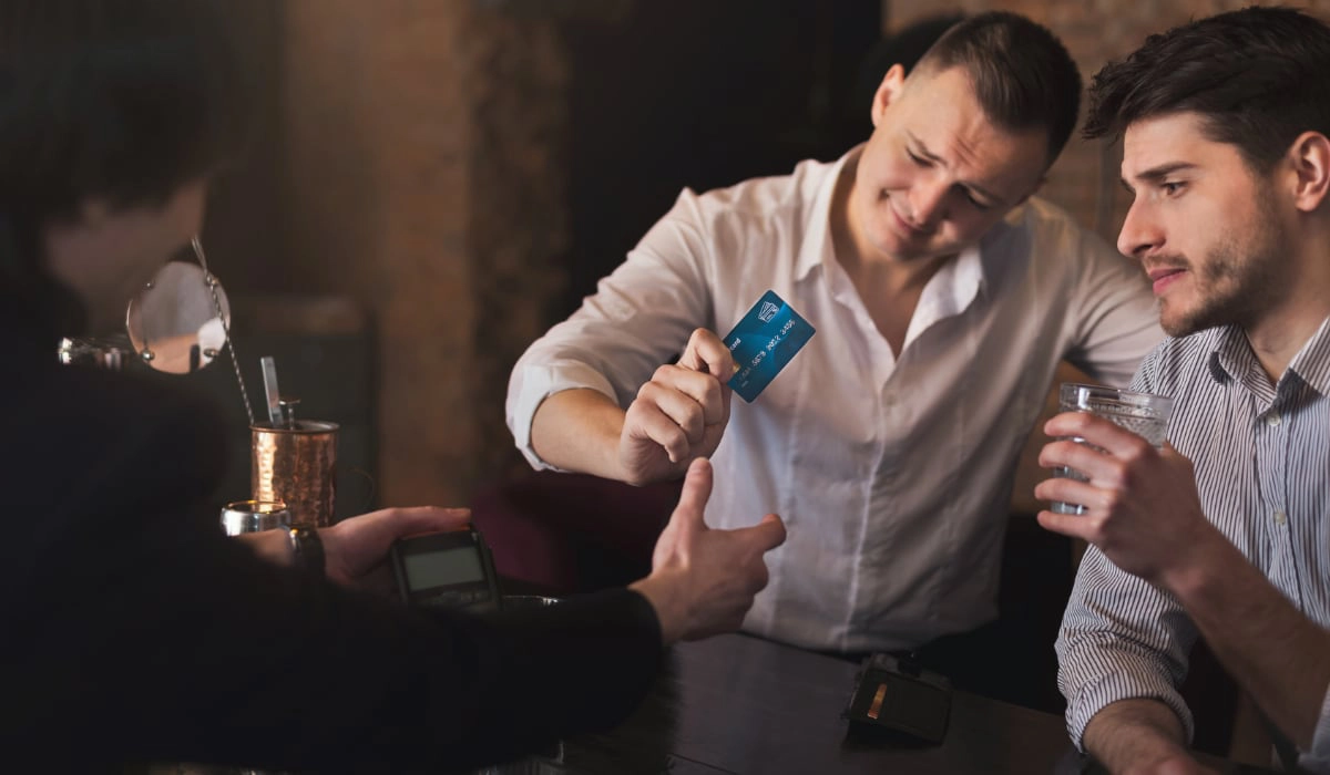 Men paying with card in a bar two men paying with card in a bar