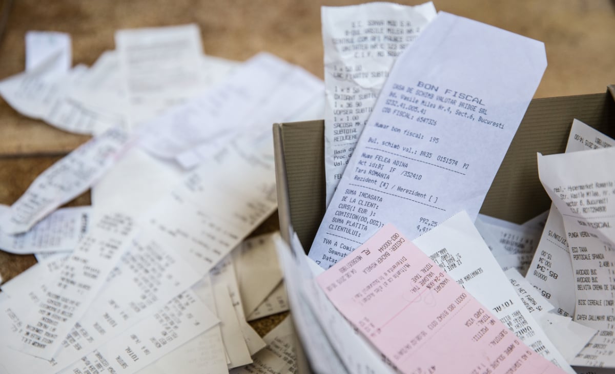 Messy paper receipts in and around a box Messy paper receipts in and around a box