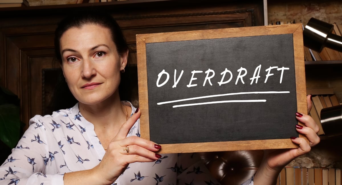 overdraft on chalkboard held by woman