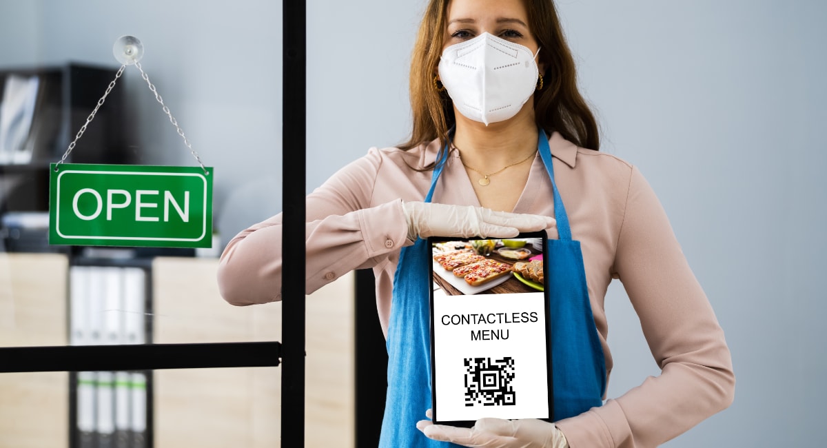 QR code menu in hands of woman by open restaurant