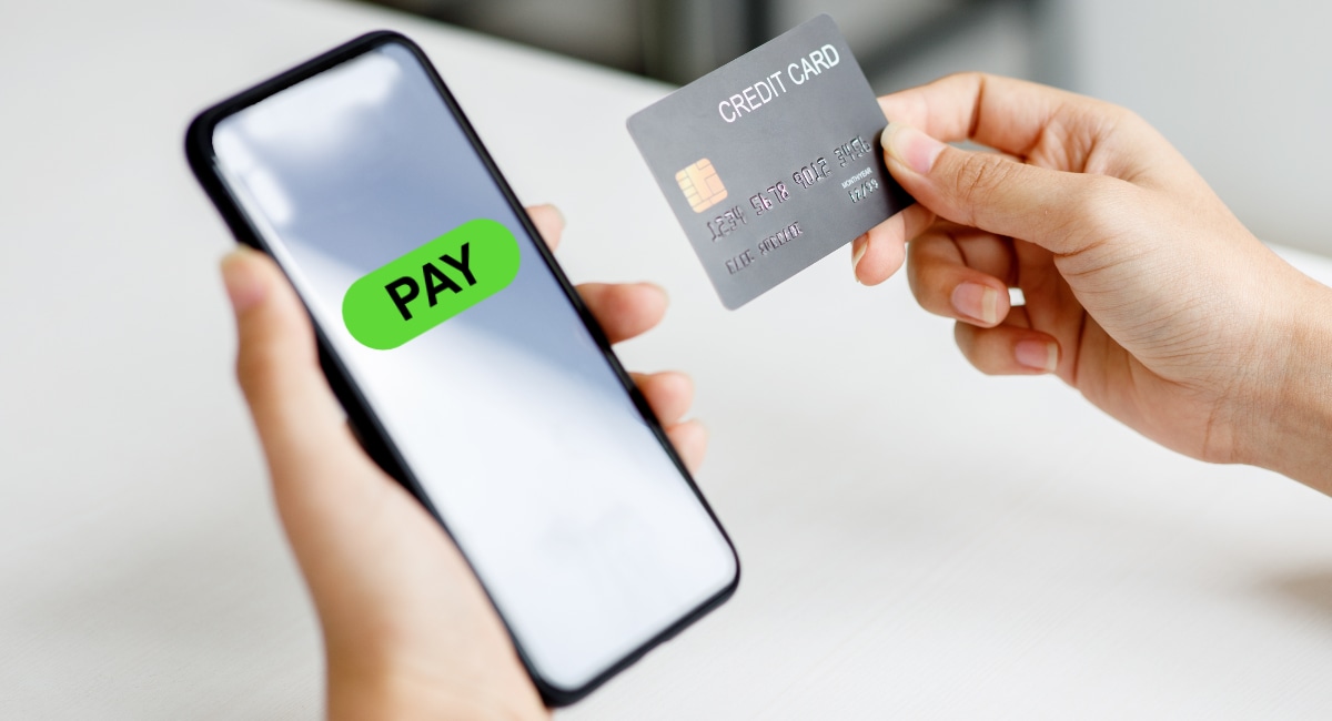 PAY link on smartphone and credit card in hand