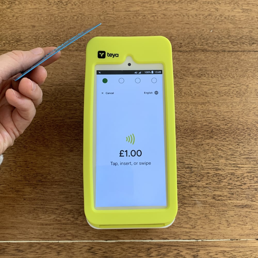 Teya payment terminal accepting a contactless card payment Hand tapping a credit card on a Teya payment terminal