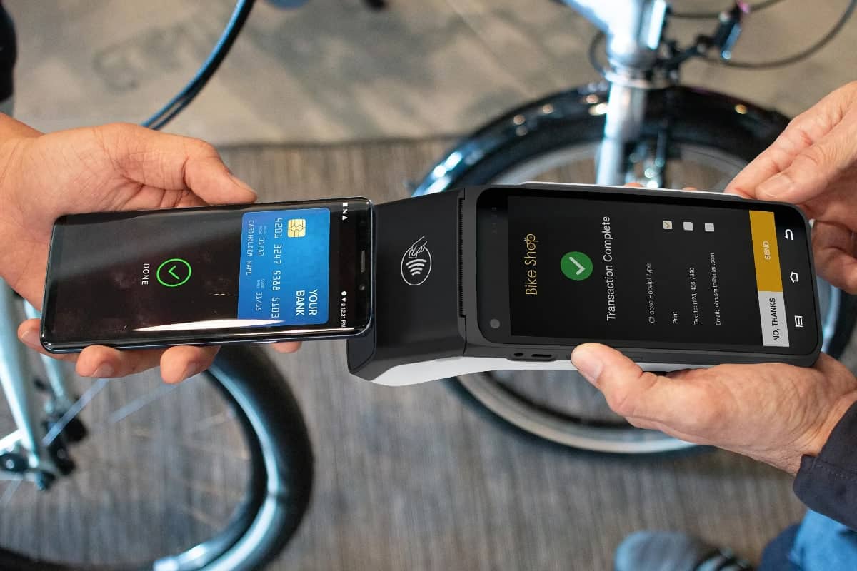 Verifone EFTPOS machine accepting a contactless mobile wallets Smart EFTPOS machine and smartphone making a mobile wallet payment